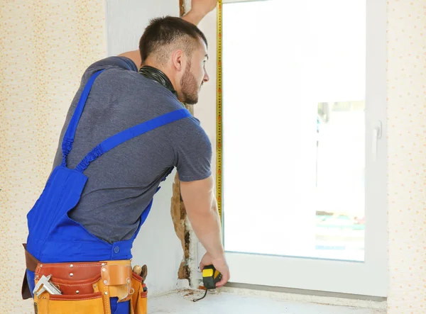 Worker repairing window in flat — Stock Photo, Image