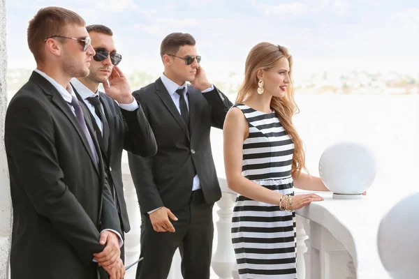 Young celebrity with bodyguards — Stock Photo, Image