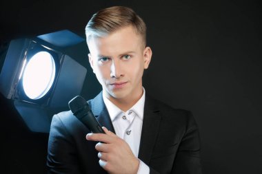 Siyah arka plan üzerinde mikrofon ile genç sunum