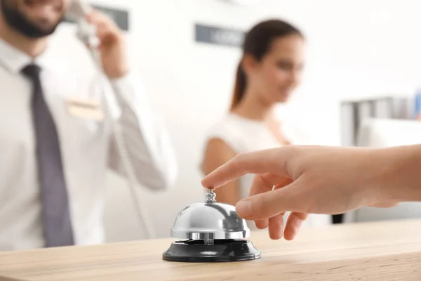 Hand of man ringing in service bell on reception desk — Stock Photo, Image