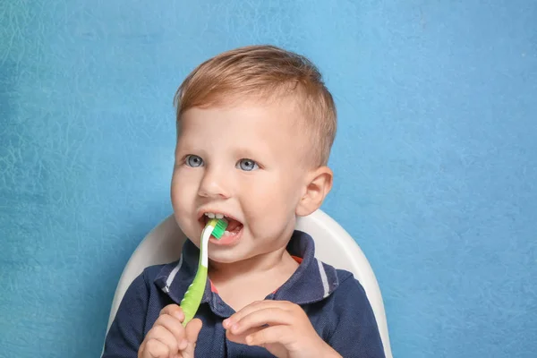 Adorable niño cepillarse los dientes en el fondo de color — Foto de Stock