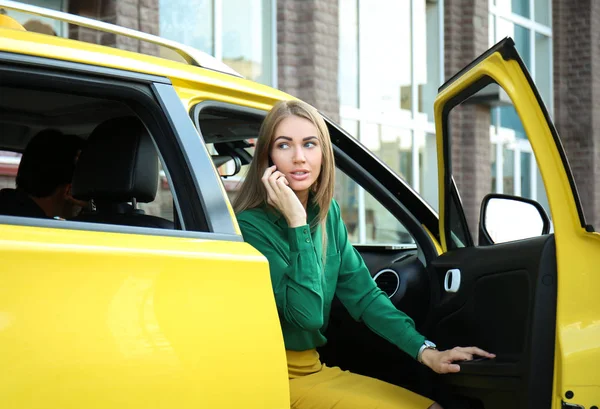 Mladá žena mluví o telefonu v taxi autě — Stock fotografie