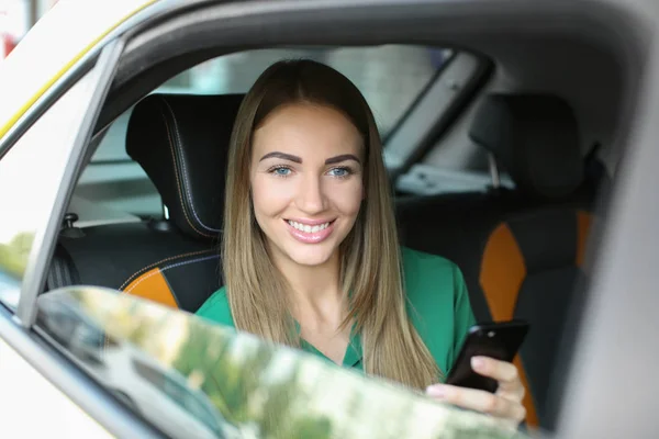 Krásná žena s telefonem seděl v taxíku — Stock fotografie