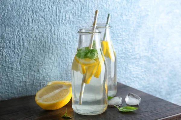 Flessen met basilicum water op tafel — Stockfoto