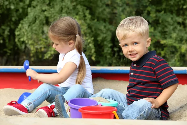 Cute little children playing in  sandbox, outdoors — Stock Photo, Image