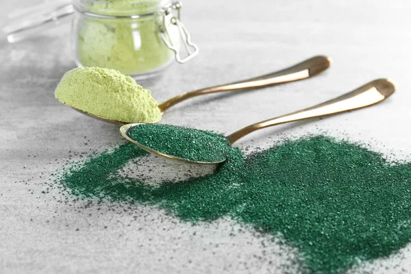 Hemp protein and spirulina powders in spoons