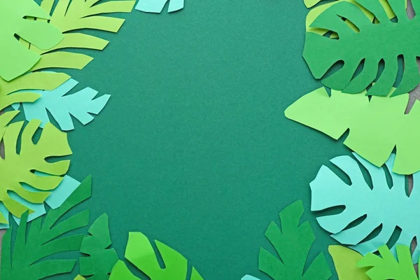 Beautiful green paper leaves on color background