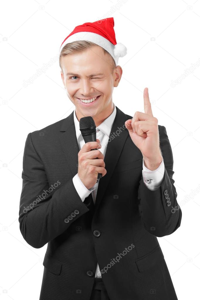 Young presenter in Santa hat with microphone on white background