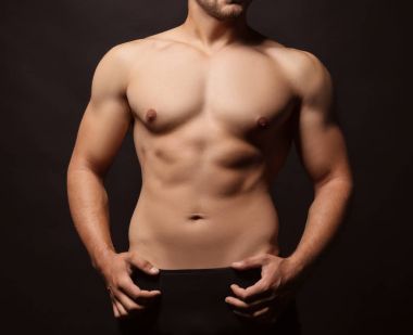 Sportif genç adam koyu arka plan üzerinde
