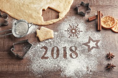 Noel kurabiyeleri ve 2018 ahşap masa üzerinde unu ile yapılan hamur