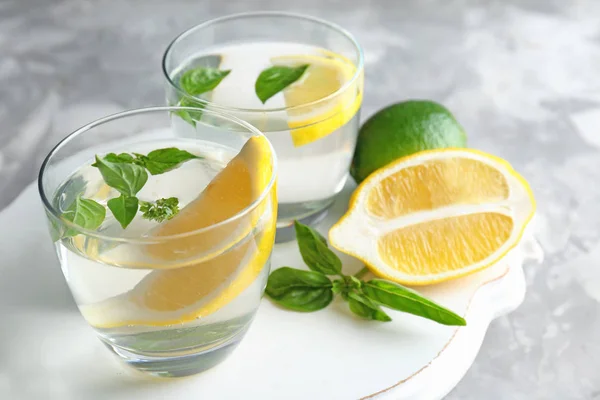 Tabla con vasos de agua de albahaca en la mesa — Foto de Stock