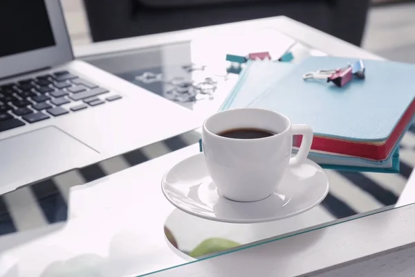 Tazza di caffè vicino al computer portatile sul tavolo — Foto Stock