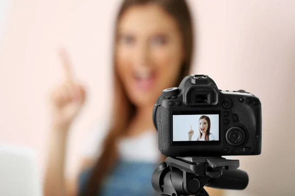 Young female blogger on camera screen