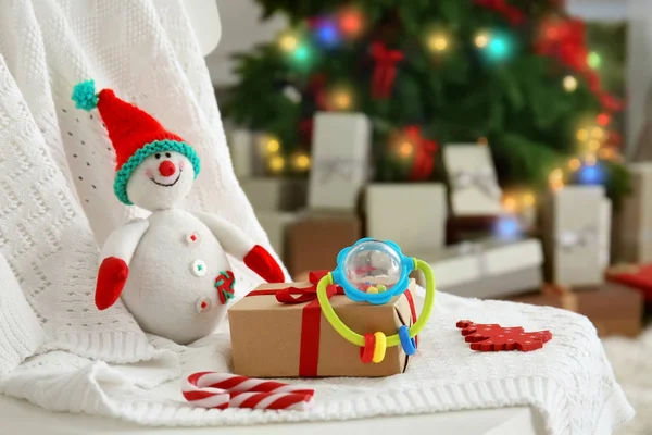 Sneeuwpop speelgoed en cadeau doos op gebreide stof binnenshuis — Stockfoto