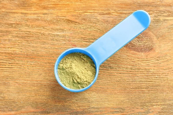 Hemp protein powder in scoop on wooden table — Stock Photo, Image