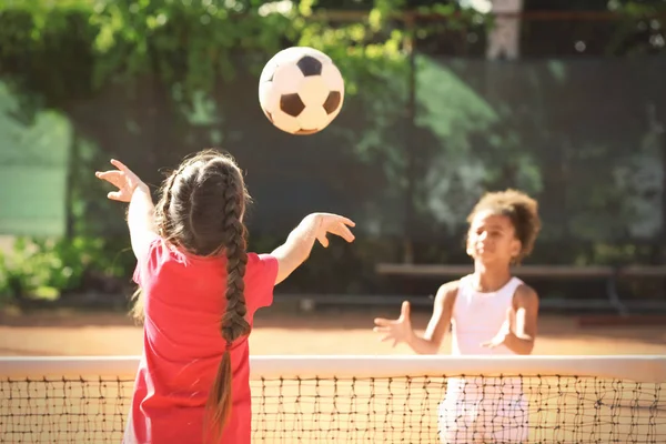 Lindos niños jugando en el campo de deportes al aire libre —  Fotos de Stock