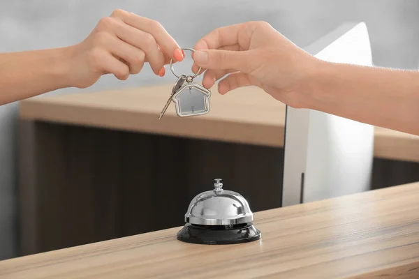 Female receptionist giving key from apartment to client — Stock Photo, Image