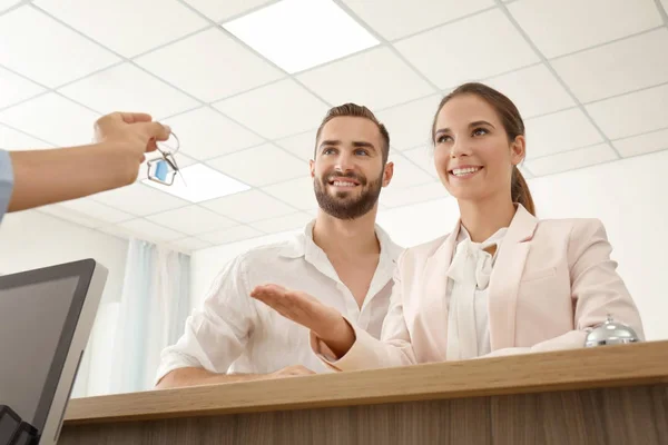 Jong koppel ontvangen sleutel van hotelkamer bij receptie — Stockfoto