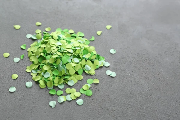 Green confetti on gray background — Stock Photo, Image