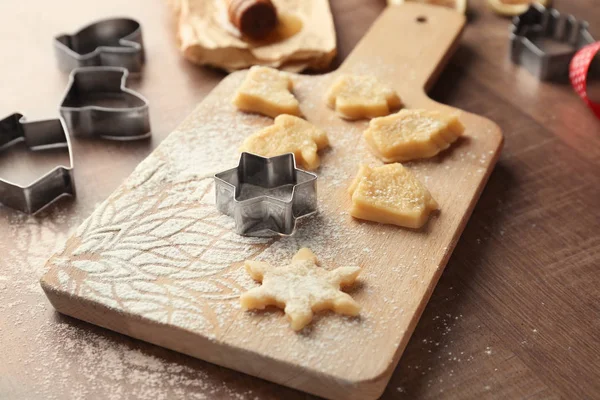 Christmas composition with raw cookies and cutters on wooden table — Stock Photo, Image