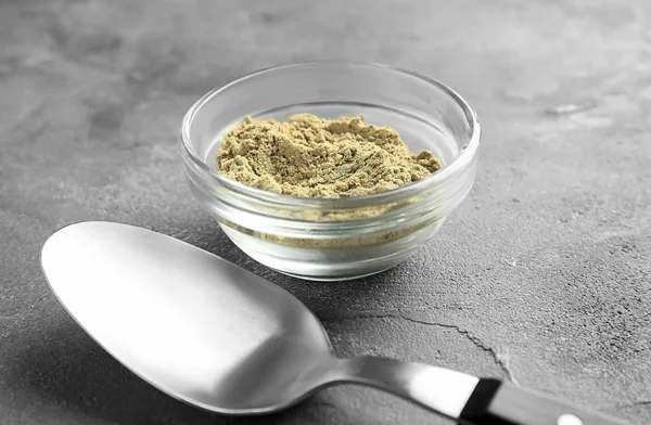 Bowl of hemp protein powder and spoon on table — Stock Photo, Image