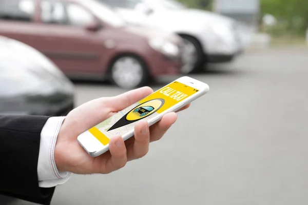 Молодий чоловік використовує додаток по телефону для виклику таксі — стокове фото