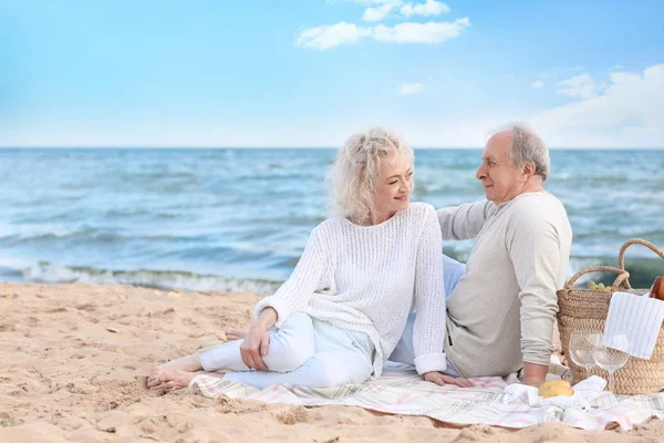 Felice coppia anziana avendo pic-nic sulla spiaggia di mare — Foto Stock