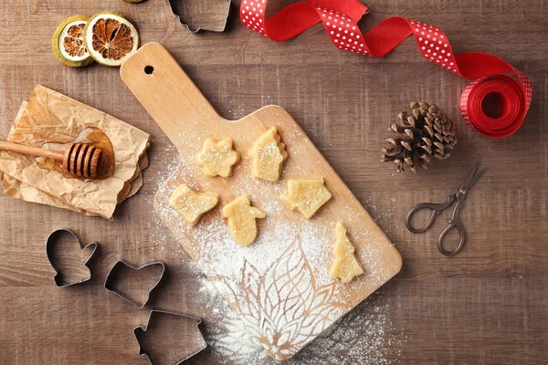 Composizione natalizia con biscotti crudi e taglierine su tavola di legno — Foto Stock