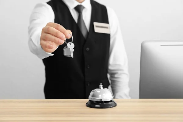 Мужчина регистратор с ключом от номера в отеле — стоковое фото