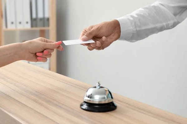 Male receptionist giving key card from hotel room to client — Stock Photo, Image