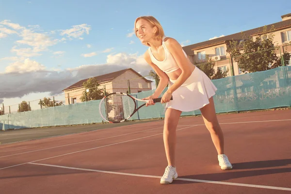 Young woman playing tennis on court — Stock Photo, Image