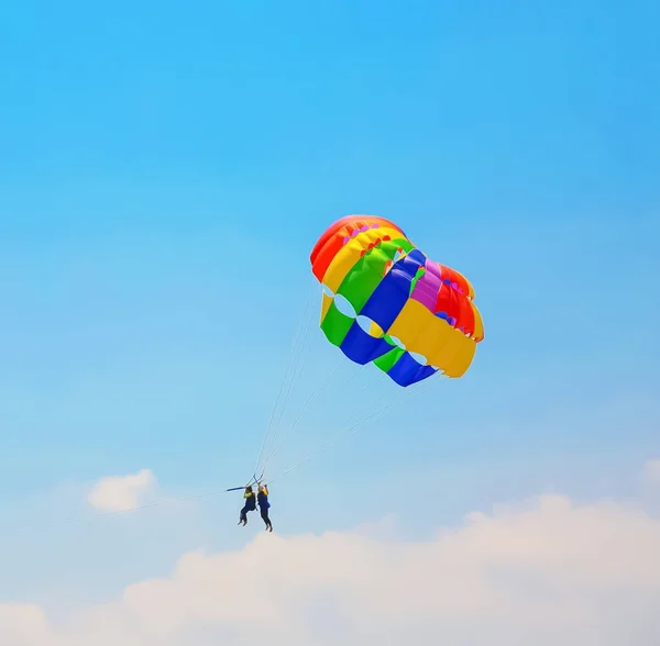 Dwie osoby ze spadochronem na słoneczny letni dzień — Zdjęcie stockowe