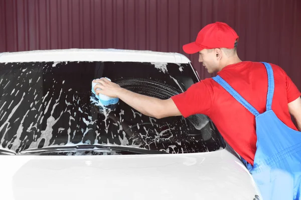 Hombre limpiando parabrisas de automóvil con esponja en el lavado de coches — Foto de Stock