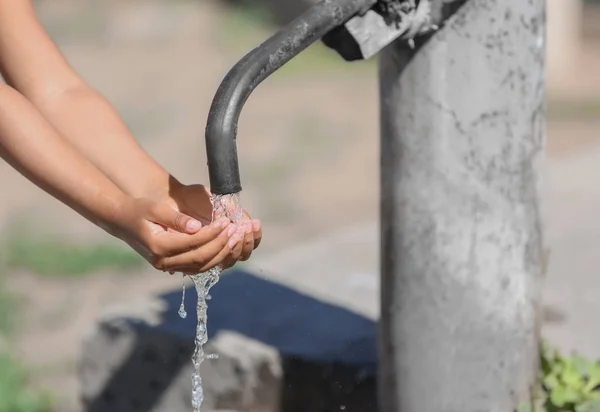 Афро-американських дітей питна вода з крана на відкритому повітрі. Концепція дефіцит води — стокове фото