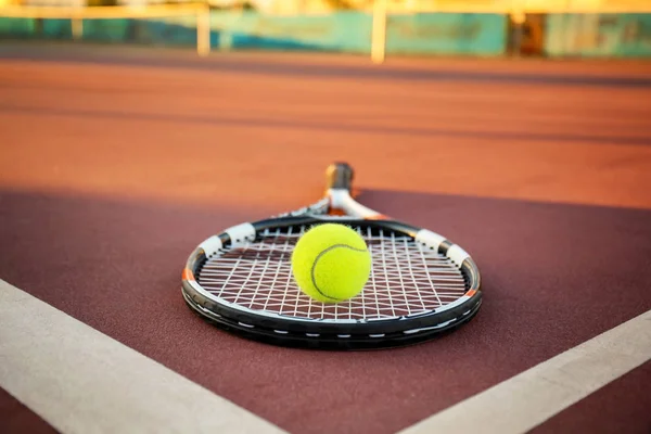 Tennis ball and racket on court — Stock Photo, Image