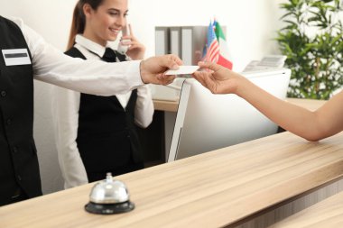 Erkek resepsiyonist kadın otel kartı teslim
