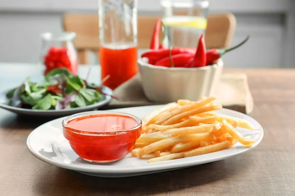 Тарелка с картошкой фри и соусом чили — стоковое фото