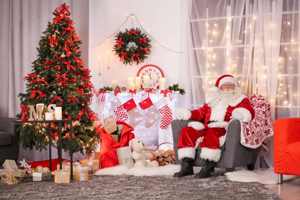 Autêntico Papai Noel sentado em poltrona no quarto decorado para o Natal — Fotografia de Stock