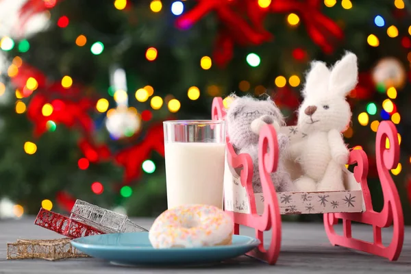 Composição de Natal com brinquedos engraçados, leite e donut no fundo embaçado — Fotografia de Stock