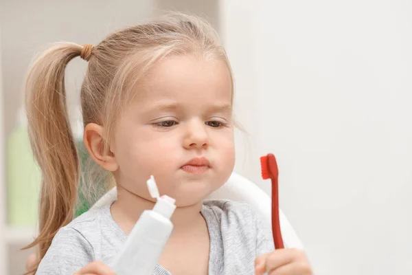 Menina escovando dentes no fundo borrado — Fotografia de Stock