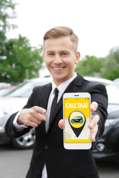 Joven llamando a taxi por celular al aire libre —  Fotos de Stock