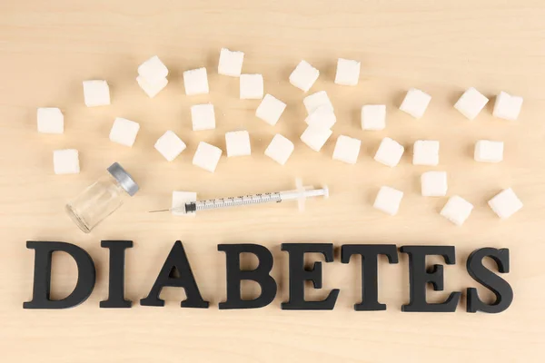 Composição com palavra Diabetes, cubos de açúcar e seringa sobre fundo claro — Fotografia de Stock