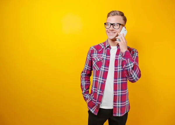 Красивый мужчина с телефоном на цветном фоне — стоковое фото