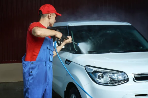 Adam araba garajında yüksek basınçlı su ile Temizleme — Stok fotoğraf