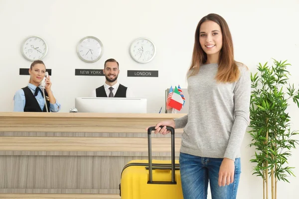 Jovem e duas recepcionistas no hotel — Fotografia de Stock