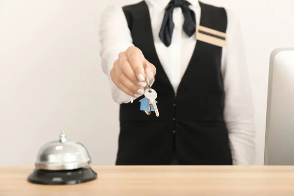 Recepcionista feminina com chave de quarto no hotel, close-up — Fotografia de Stock