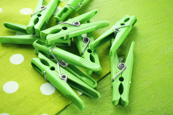 Green clothes pins on color table