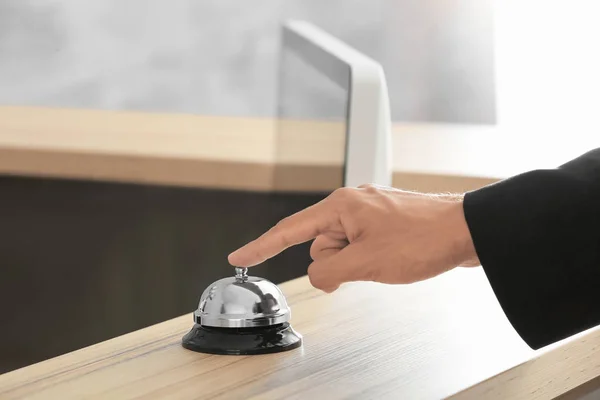 Man ringing service bell at hotel reception — Stock Photo, Image