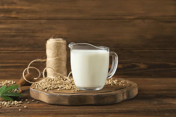 Jarro com leite de cânhamo saudável na mesa de madeira — Fotografia de Stock