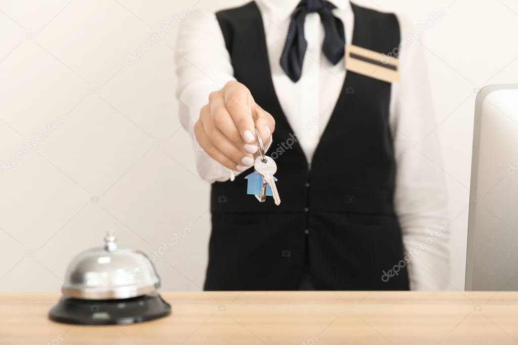 Female receptionist with room key in hotel, closeup